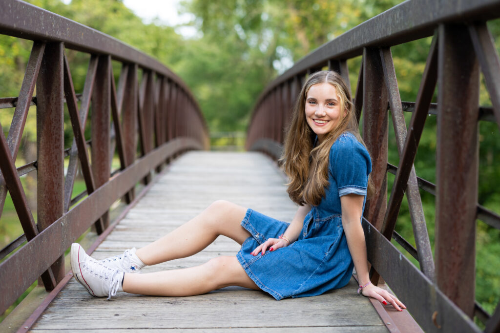 teenager sitting across a bridge