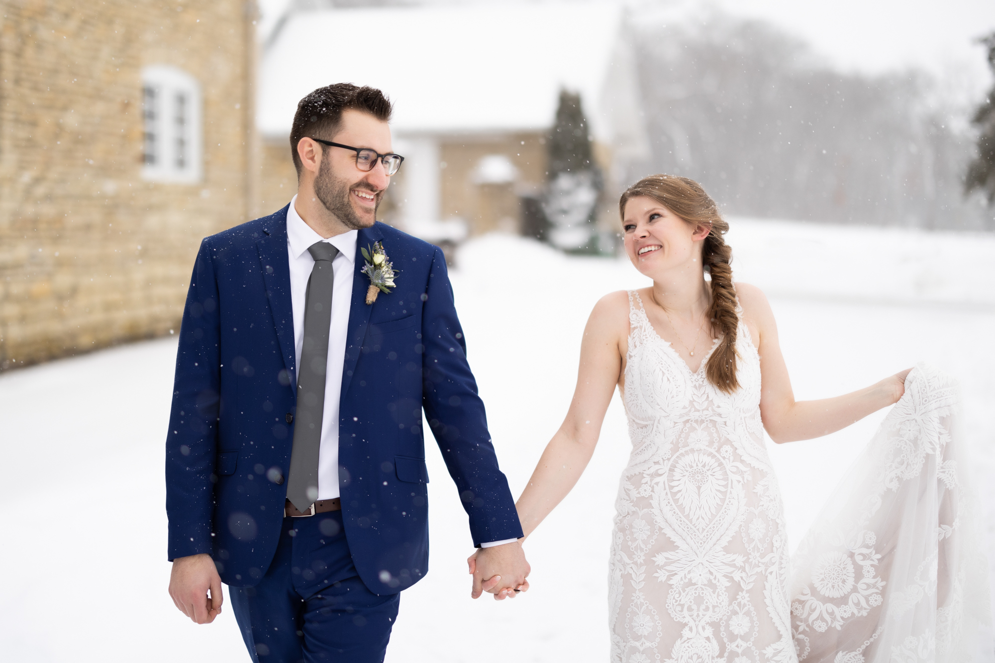 bride and groom walking through the snow